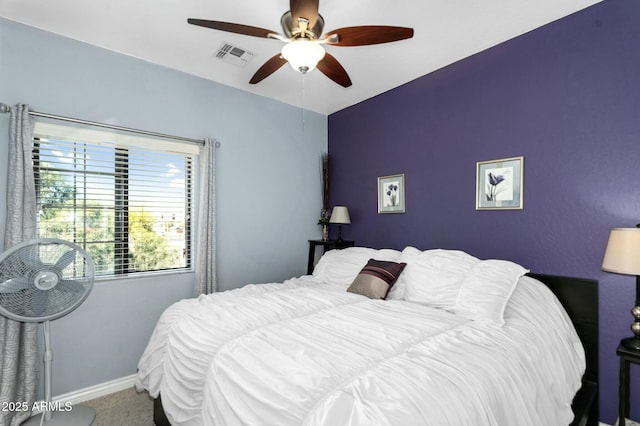 carpeted bedroom with visible vents, a ceiling fan, and baseboards