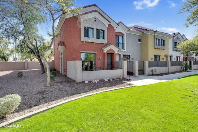 view of front of house with stucco siding, a fenced front yard, a front lawn, and a tile roof