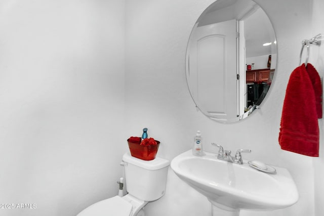 half bath with toilet and a sink