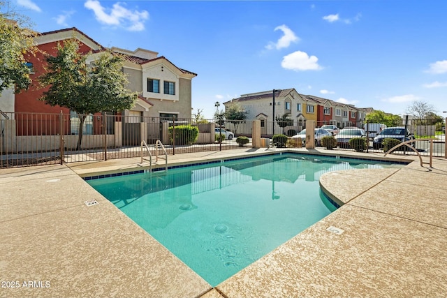 community pool featuring a patio area, a residential view, and fence