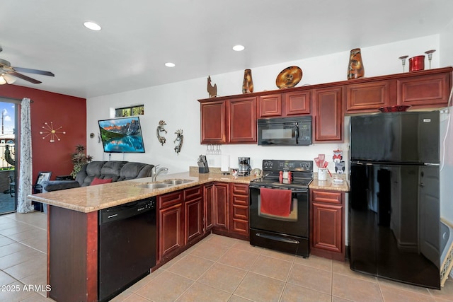 kitchen with a sink, reddish brown cabinets, black appliances, and a peninsula