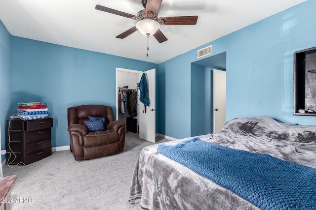 bedroom featuring ceiling fan, a closet, light colored carpet, and a spacious closet