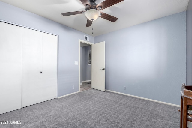 unfurnished bedroom featuring ceiling fan, a closet, and light colored carpet