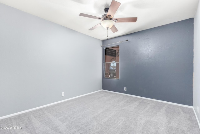 carpeted spare room featuring ceiling fan