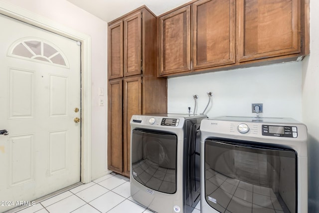 laundry area with cabinets, light tile patterned floors, and separate washer and dryer