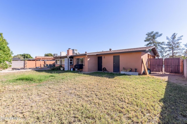 rear view of property featuring a lawn