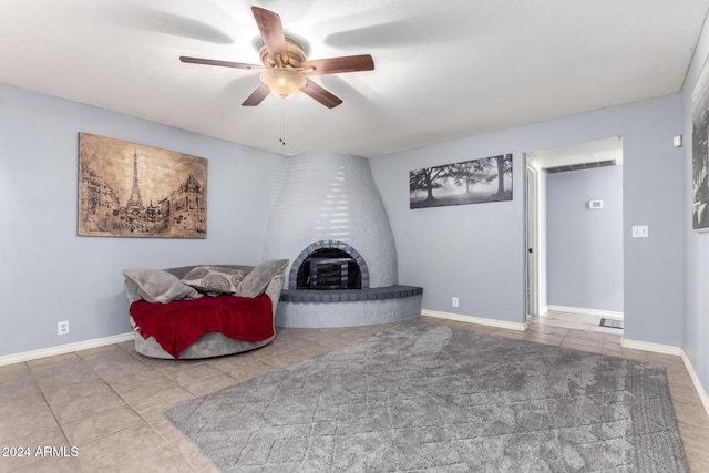 sitting room featuring tile patterned flooring, ceiling fan, and a fireplace