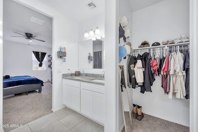 bathroom with ceiling fan, tile patterned flooring, and vanity