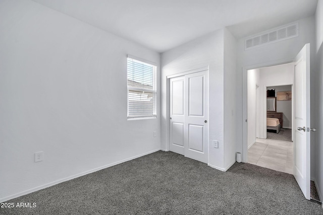 unfurnished bedroom featuring carpet and a closet