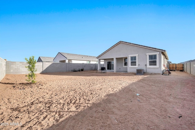 back of property with central AC and a patio area