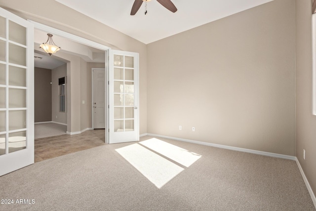 spare room featuring ceiling fan, carpet floors, and french doors