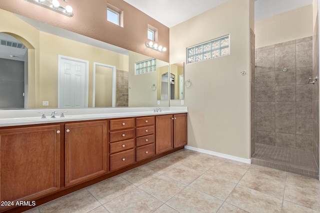 bathroom featuring tile patterned flooring, vanity, and tiled shower