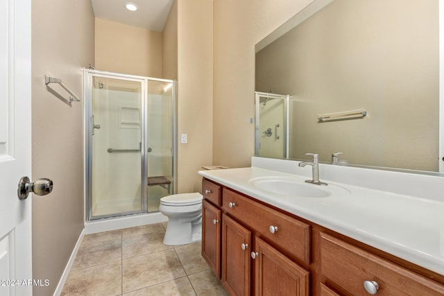 bathroom featuring toilet, vanity, tile patterned floors, and a shower with shower door