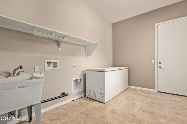 laundry room featuring electric dryer hookup, light tile patterned flooring, sink, and hookup for a washing machine