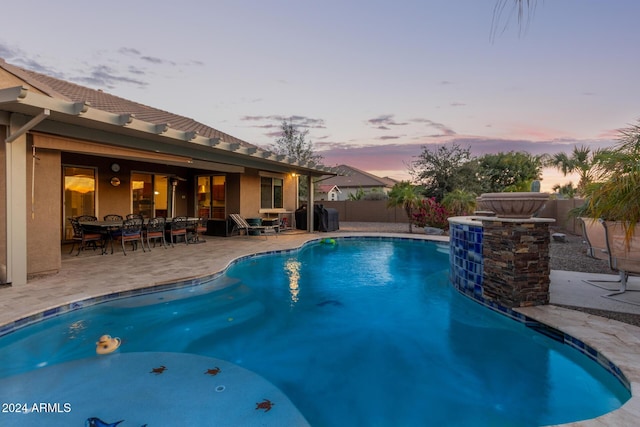 pool at dusk with a patio