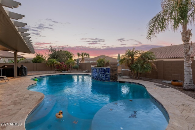 pool at dusk featuring a patio area