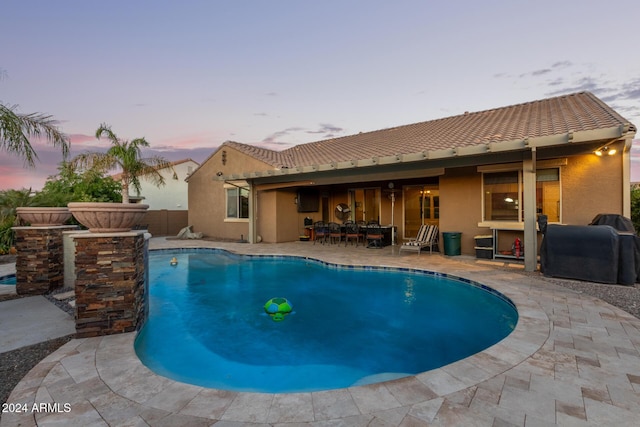 pool at dusk with a patio