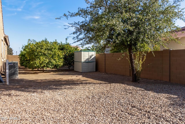 view of yard featuring central AC unit and a storage shed