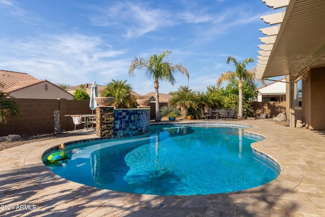 view of swimming pool featuring exterior bar and a patio