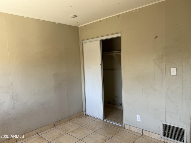 unfurnished bedroom featuring light tile patterned floors, a closet, and visible vents