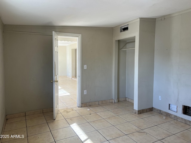 unfurnished bedroom featuring a closet and light tile patterned floors