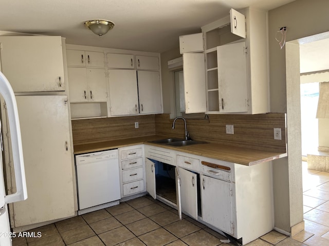 kitchen featuring open shelves, backsplash, white dishwasher, and a sink