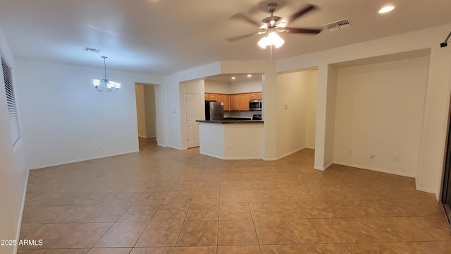 unfurnished living room featuring ceiling fan with notable chandelier, visible vents, and baseboards