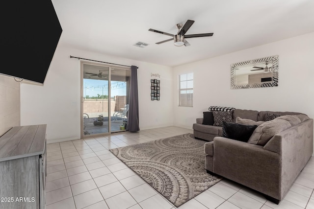 living room featuring ceiling fan, light tile patterned floors, and baseboards
