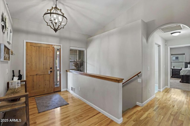 foyer entrance with a chandelier and light wood-type flooring