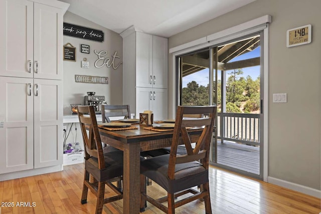 dining area featuring lofted ceiling and light hardwood / wood-style flooring