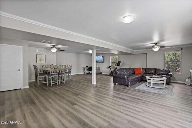 living room with ornamental molding, wood-type flooring, and ceiling fan