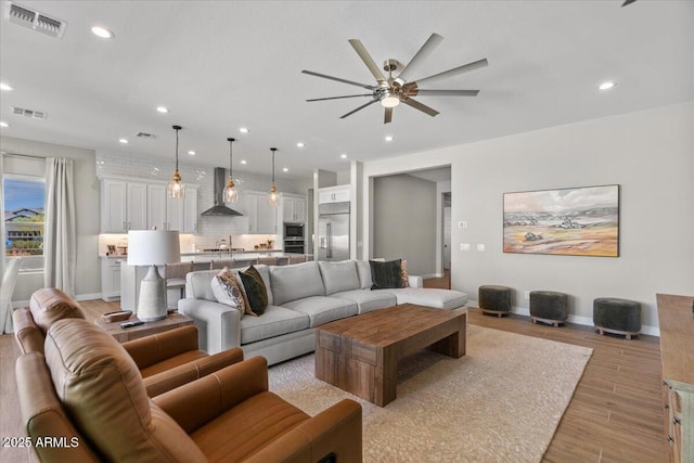 5860 E Sanford St, Mesa, AZ 85215 - living area featuring visible vents, light wood-style flooring, a ceiling fan, and recessed lighting