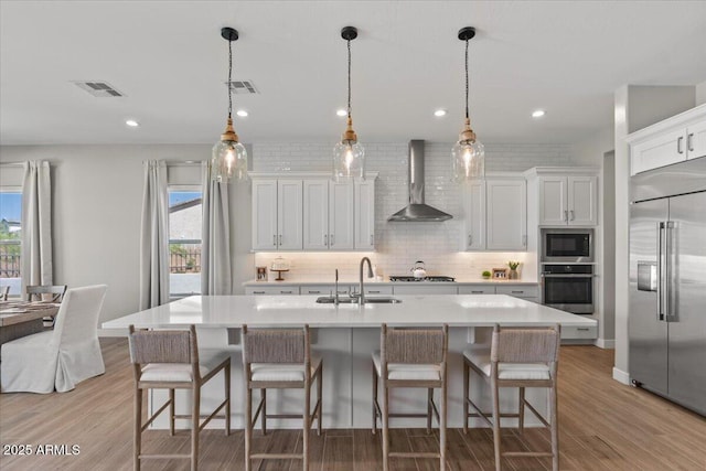 5860 E Sanford St, Mesa, AZ 85215 - kitchen featuring wall chimney exhaust hood, visible vents, light countertops, a sink, and built in appliances