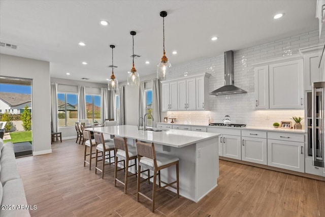 5860 E Sanford St, Mesa, AZ 85215 - kitchen featuring wall chimney exhaust hood, a sink, light countertops, a center island with sink, and gas cooktop