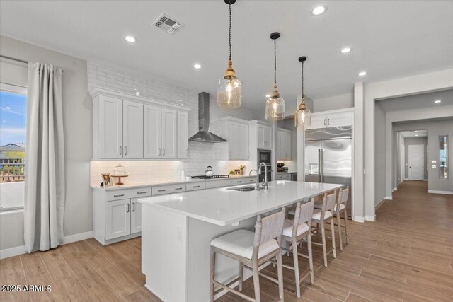 5860 E Sanford St, Mesa, AZ 85215 - kitchen featuring tasteful backsplash, wall chimney range hood, a sink, built in appliances, and baseboards
