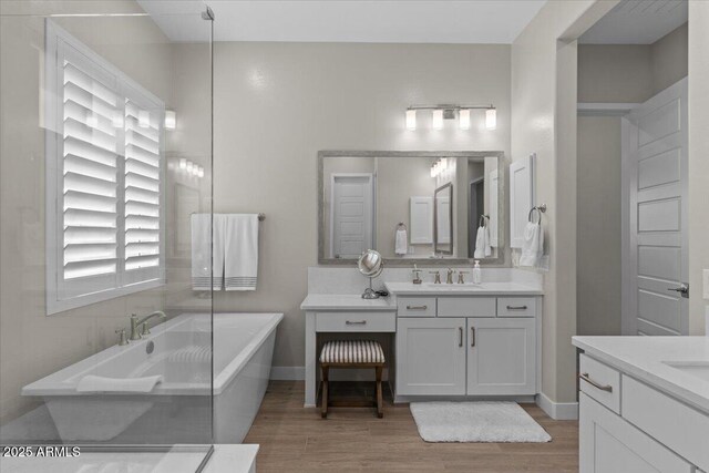 5860 E Sanford St, Mesa, AZ 85215 - full bathroom with two vanities, a freestanding tub, a sink, and wood finished floors