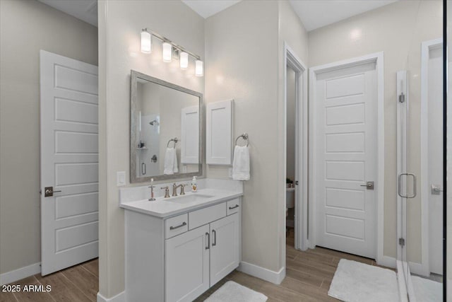5860 E Sanford St, Mesa, AZ 85215 - full bathroom featuring vanity, baseboards, a stall shower, and wood finished floors