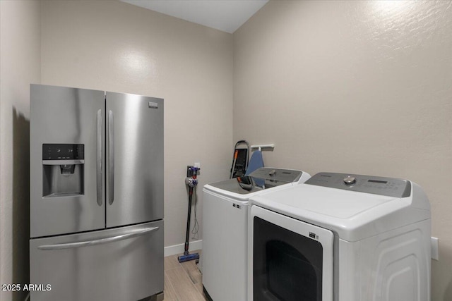 5860 E Sanford St, Mesa, AZ 85215 - clothes washing area featuring washer and dryer, laundry area, light wood finished floors, and baseboards