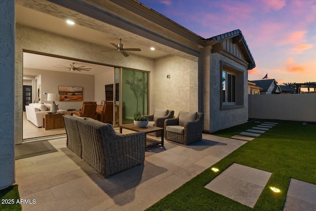 5860 E Sanford St, Mesa, AZ 85215 - patio terrace at dusk with an outdoor living space, fence, a lawn, and a ceiling fan