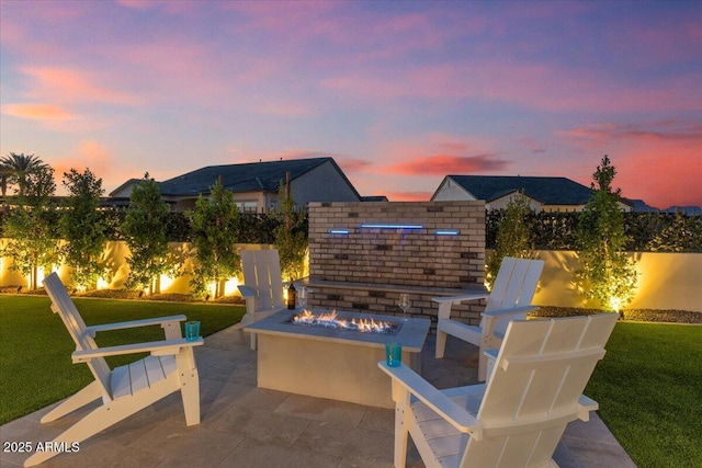 5860 E Sanford St, Mesa, AZ 85215 - patio terrace at dusk featuring a yard, fence, and an outdoor fire pit