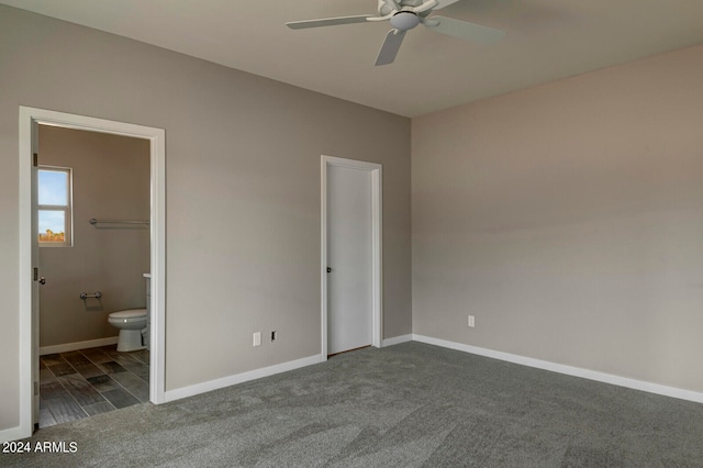 unfurnished bedroom featuring dark carpet, connected bathroom, a closet, and ceiling fan