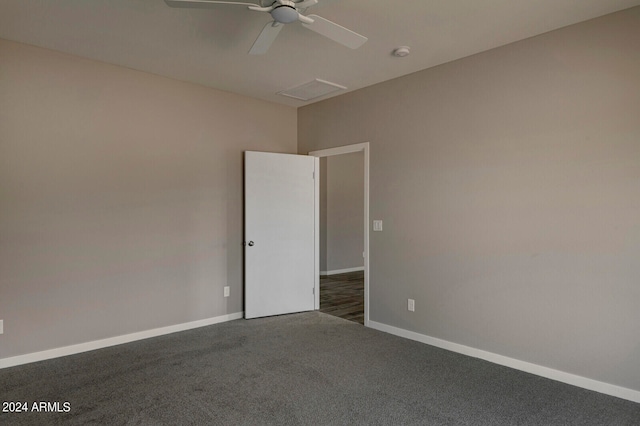 spare room with ceiling fan and dark carpet