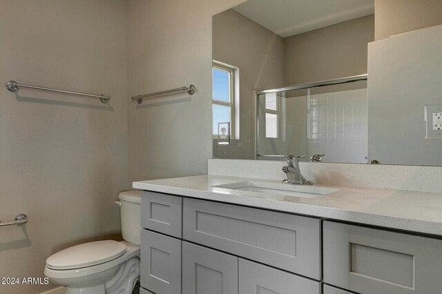 bathroom with vanity, toilet, and an enclosed shower