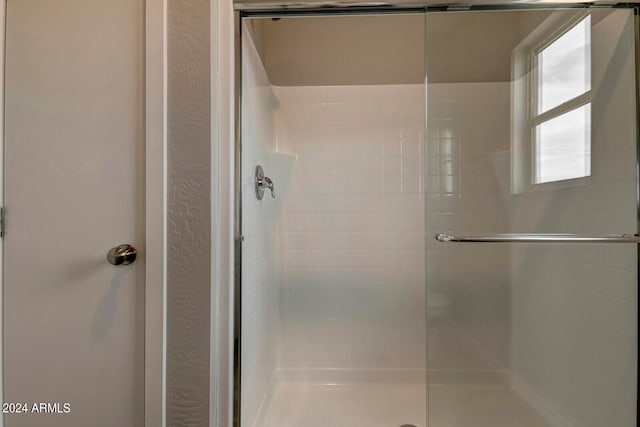 bathroom with a shower with door