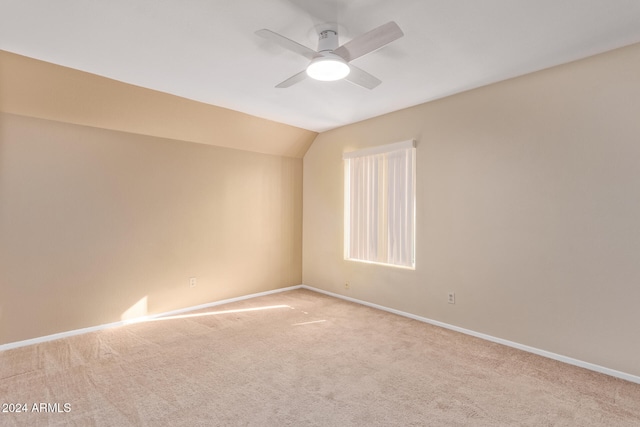 carpeted empty room featuring ceiling fan and vaulted ceiling