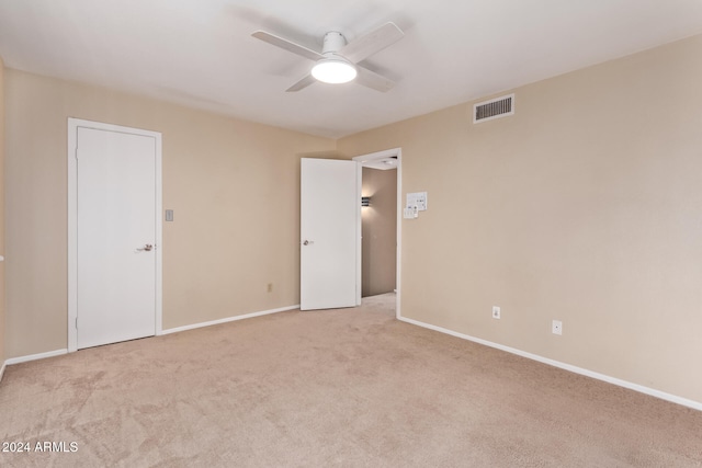 carpeted spare room with ceiling fan