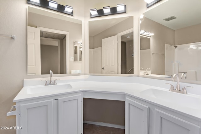 bathroom with tile patterned floors, vanity, and walk in shower