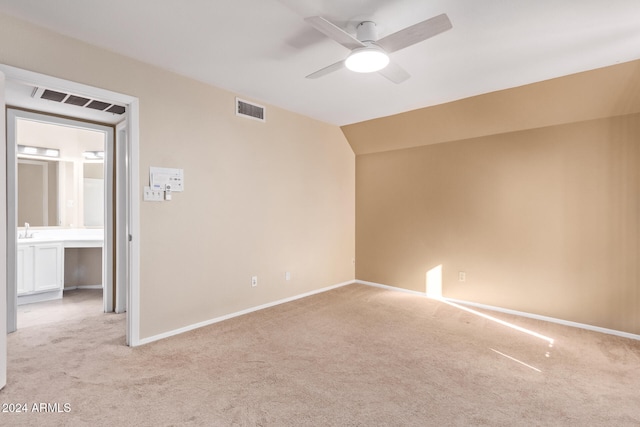 spare room with ceiling fan, sink, lofted ceiling, and light carpet