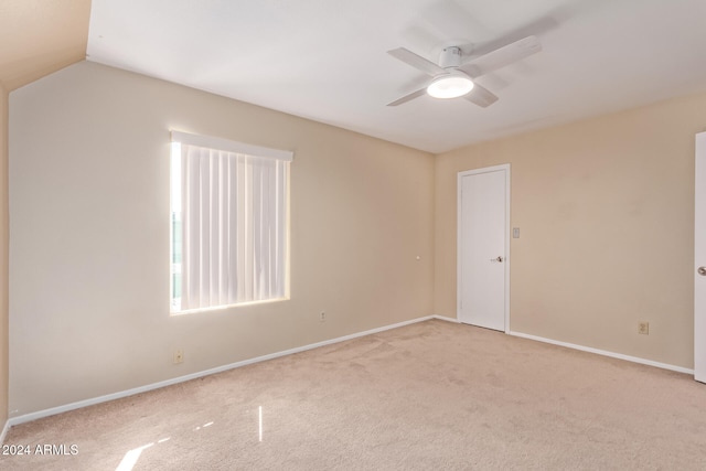 unfurnished room featuring ceiling fan, light colored carpet, and lofted ceiling