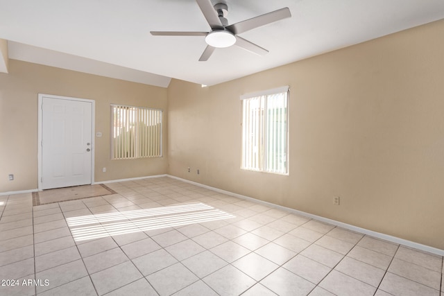 tiled spare room with ceiling fan